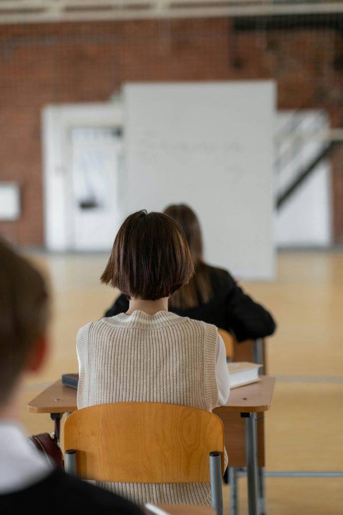 Focused students seated in class, attentively looking towards the whiteboard.
